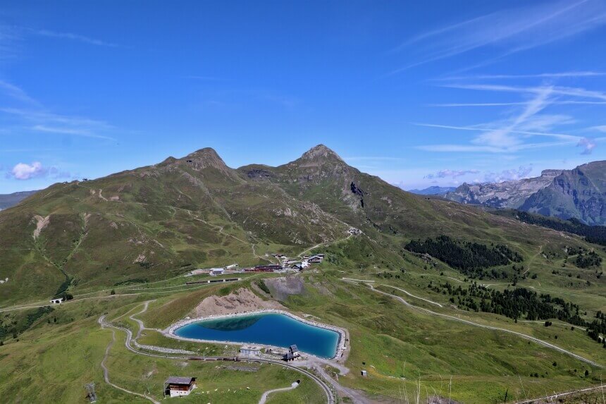 Uitzicht vanaf Eigergletscher, met de besneeuwde bergtoppen achter je. Beneden zie je Kleine Scheidegg liggen.